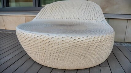 Poster - A closeup of a unique sculptural seating element crafted from recycled plastic highlighting its textured surface and organic form inviting users to interact with the space.