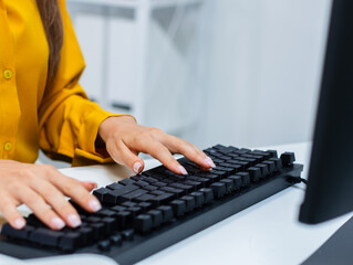 back view shot of female programmer and software developer working on desktop computer writing code 