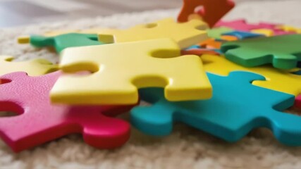 Aufkleber - A closeup of brightly colored puzzles tered on a plush carpet focusing on the unique shapes and vivid imagery of the assembled pieces.