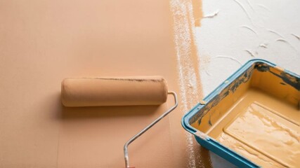 Aufkleber - A vividly colored paint roller gliding across a smooth beige wall leaving behind a thick even application of paint with visible texture.