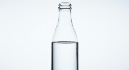 Poster - Close up of a clear glass bottle partially filled with a clear liquid against a white background
