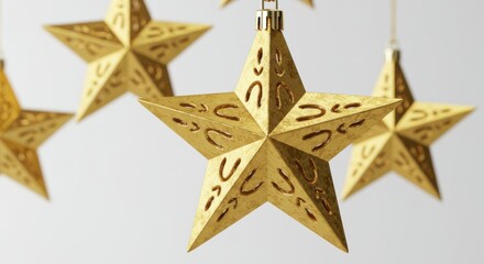 Poster - Close up of golden christmas star ornaments with intricate designs hanging against a white background