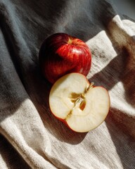 Poster - Two fresh red apples on linen cloth in sunlight still life arrangement studio shot food photography clean background healthy lifestyle concept natural light and shadow