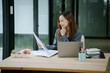 © PSG - Beautiful asian businesswoman checks documents in meeting room. Young smiling female manager looks camera. Successful sales woman holds financial papers, dressed formal beige suit in office.