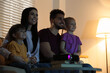 © New Africa - Happy family watching movie using video projector at home