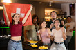 © JackF - Group of friends fans watching match cheering with Swiss flag in bar