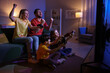 © New Africa - Happy family playing video games in living room at night