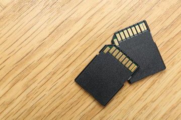 Poster - Two SD memory cards on light wooden table, top view. Space for text