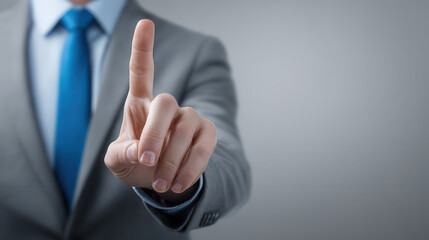 A man in a suit is pointing at a button on a screen
