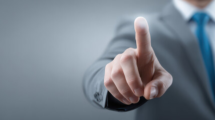 a man in a suit is pointing at a button on a screen