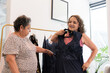 © Daniel Zapata/Stocksy - Two elderly women in a store trying on evening dresses.