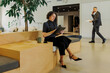© BONNINSTUDIO/Stocksy - Formal businesswoman working on digital tablet in modern office lobby