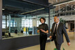 © BONNINSTUDIO/Stocksy - Formal business people walking and talking in modern office lobby