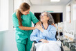 © Santi Nuñez/Stocksy - Doctor comforting elderly patient in wheelchair in hospital corridor