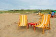 © Anna Tsukanova/Stocksy - Vibrant yellow chaise lounge chairs on the beach in summer