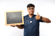 © ArvStd - Thinking Asian nurse with bulletin.Holding blank message board and showing thumb up