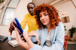 © Adrian Rodd/Stocksy - Angular close-up view of two people in a modern workspace