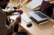 © Jovo Jovanovic/Stocksy - Man reading business documents by laptop on desk at home office