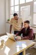 © BONNINSTUDIO/Stocksy - Two businessmen collaborating on laptop in modern office