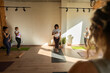 © Alvaro Lavin/Stocksy - Yoga instructor guiding group of women practicing breathing