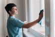 © masyastadnikova - 12-year-old boy doing household chores at home: cleaning windows. Daily routine of a responsible child.
