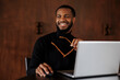 © BONNINSTUDIO/Stocksy - Smiling businessman working on laptop in elegant office