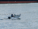 Fishing Boat Passing Huge Freighter