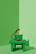 © Juan Moyano/Stocksy - green desk with a red telephone off the hook