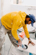 © Adrian Rodd/Stocksy - Working man using a handheld cutter to cut ceramic floors