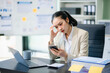 © laddawan - Asian woman talking on the phone with a customer Young positive female accountant using smartphone talking