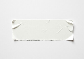 Poster - Close-up of a blank white sticker with torn edges on a white surface, ideal for adding text or design