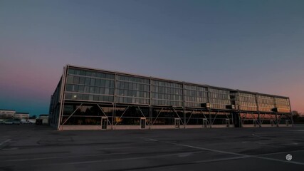 Poster - Sunrise Over Modern Factory with Reflections on Glass Facade