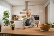 © Miljan Živković - Young woman work on laptop at kitchen at home