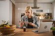© Miljan Živković - Young woman read instruction for medical browse internet at kitchen