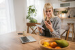 © Miljan Živković - Young woman read instruction for medical browse internet at kitchen
