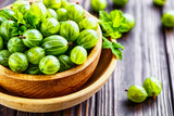 Green Organic Berries Gooseberries.Green gooseberries in a wooden bowl.Gooseberries on the wooden table. Harvest concept. Vegetarian food.