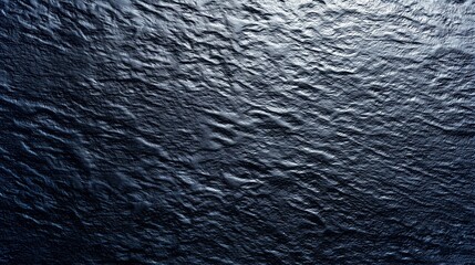 Poster - Dark textured surface resembling ocean waves under soft lighting for eco-friendly projects