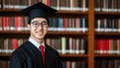 © Adex - Smiling graduate portrait in library with blurred bookshelves