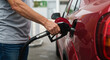 © Tatiana - Person refueling a red car at a gas station