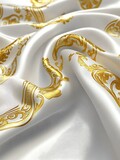 Luxurious white silk fabric with a gold baroque pattern, elegantly draped and showcasing its texture and sheen. The image highlights the rich details of the design and the luxurious feel of the