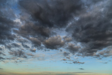 Wall Mural - Storm dark grey cumulus rain clouds against blue sky abstract background texture, thunderstorm