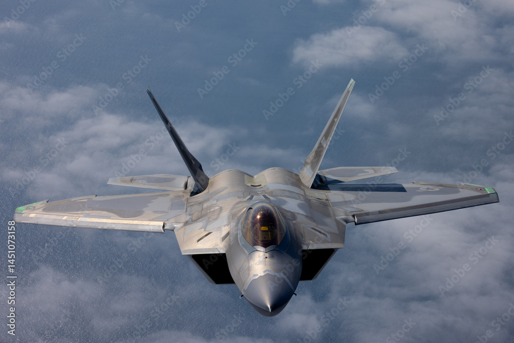 Frontal view of a a F-22 Raptor flying over the Pacific ocean and a ...
