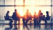 © Pixelzone - A stunning image of business team meeting, silhouette of business people in an office conference room sitting around a table discussing work together. Abstract blurred background.