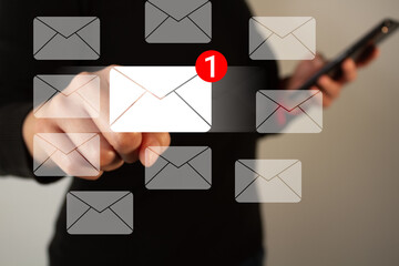 Poster - Businesswoman pointing at an email icon with notification, surrounded by several envelopes, while holding a cell phone with the other hand