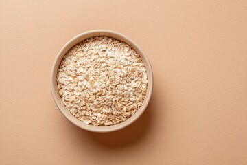 Poster - single bowl of oatmeal stands elegantly on smooth solid color background with ample copy space