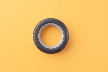 Poster - top-down view of single car tire centrally placed over 70 ample copy space all against clean solid color background