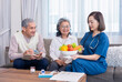© Verin - home health care nurse in uniform explaining nutritional value of fruits,vitamins and dietary fiber to senior couple,old man writing on notebook