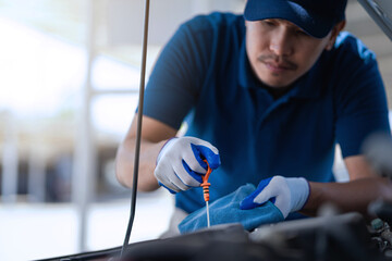 Fototapete - A man is working on a car engine, checking the oil level