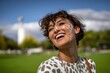 © Antony - Smiling woman enjoying a sunny day in a green park with dramatic clouds