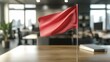 © muhammadfitrah - A red flag displayed prominently on a desk in a modern office space.